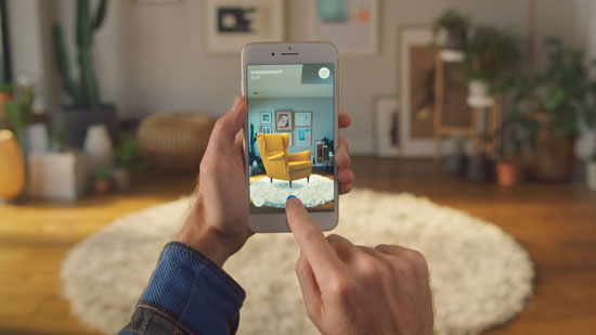 Hands holding a phone in a room while using the IKEA Place AR app