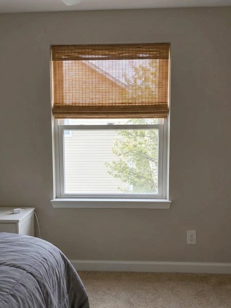 Natural woven bamboo shade visualized on a real bedroom window