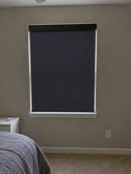 Black blackout roller shade previewed on a bedroom window with DecorViz