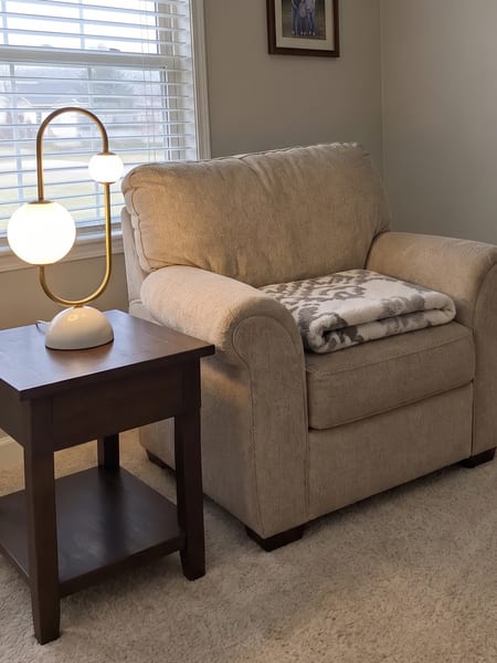 Lampe de table à globe en verre et laiton prévisualisée sur une table d'appoint dans un vrai salon