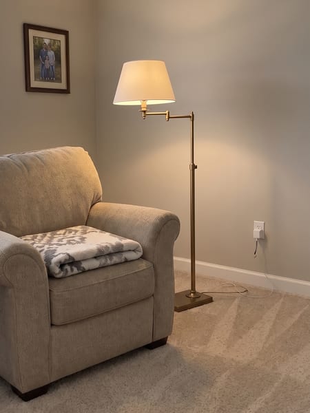 Lampadaire de lecture en laiton à bras articulé placé près d'un fauteuil avec DecorViz